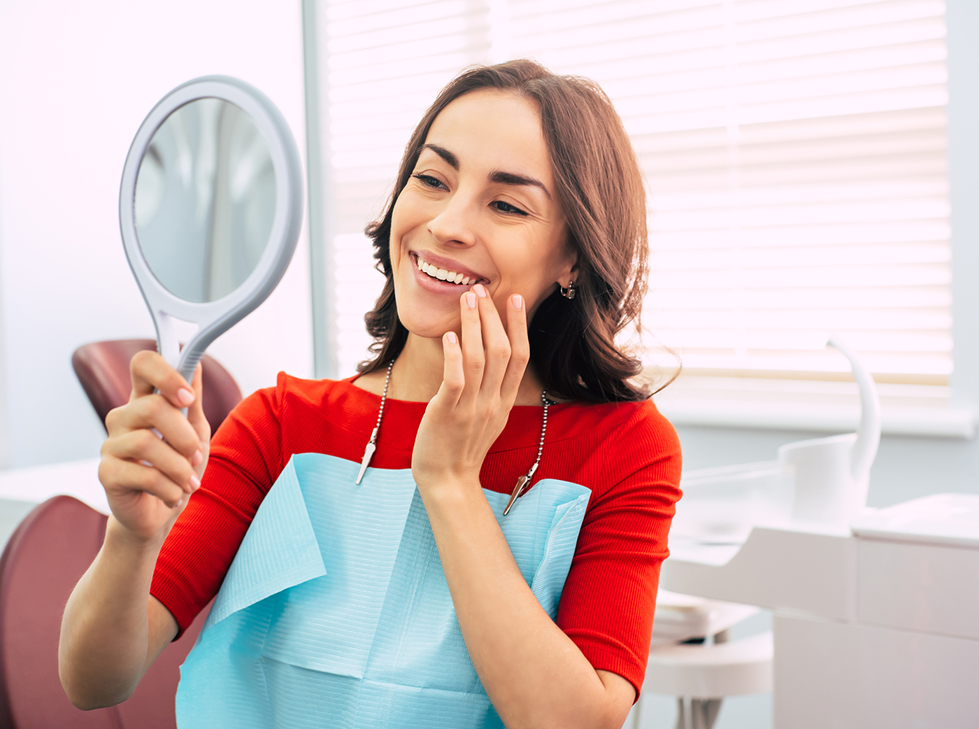 girl in dentist cabinet is using a mirror to look through the ideal work of a doctor